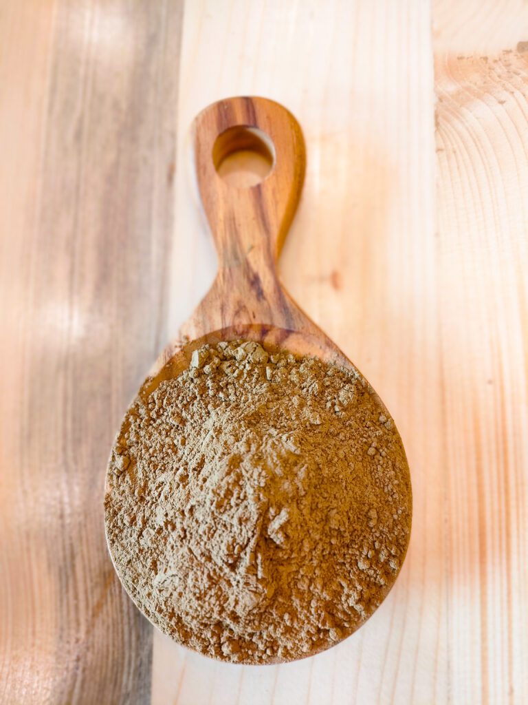 Red Kratom powder on a wooden spoon